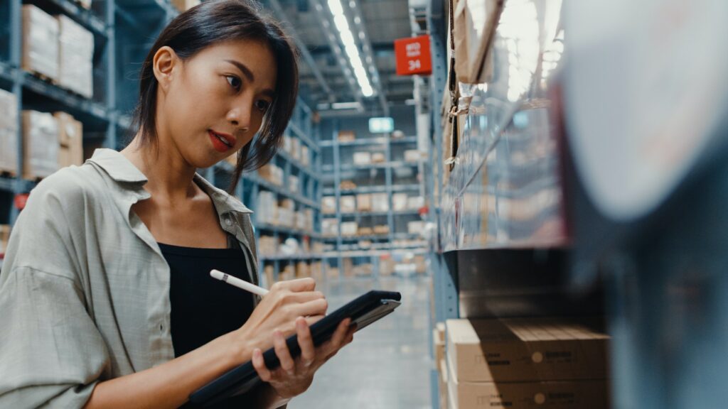 businesswoman manager looking for goods using digital tablet checking inventory levels standing